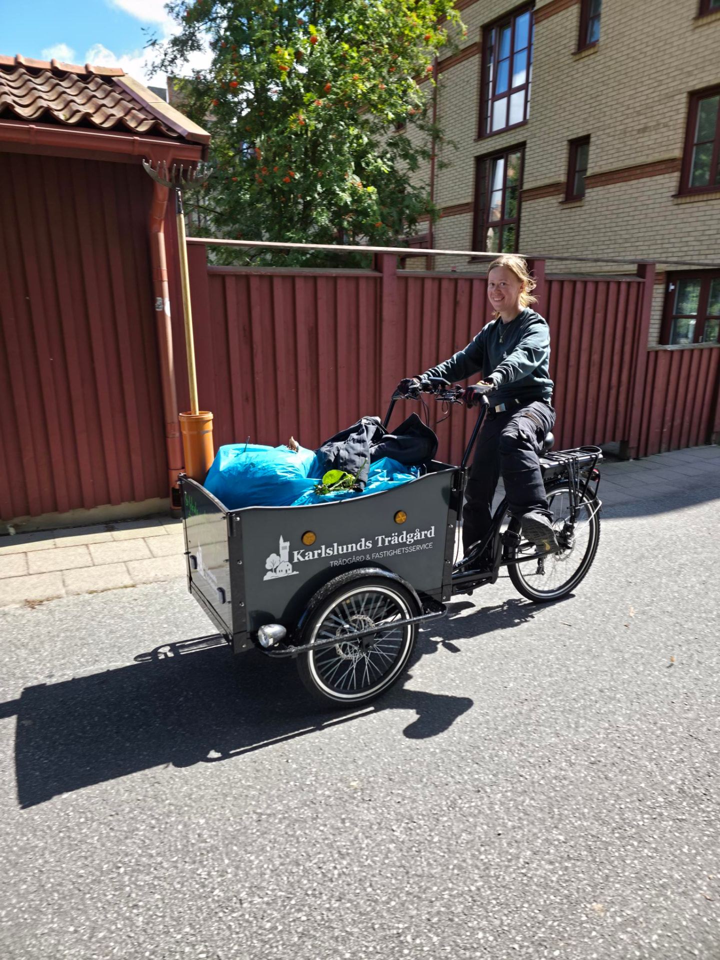 Medarbetare på Karlslunds Trädgårds lastcykel med trädgårdsavfall